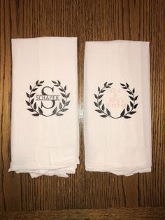 two white towels with black monogrammed wreaths and the word schappr on them