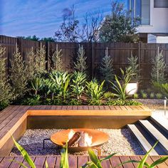 a wooden bench sitting in the middle of a garden next to a tall planter