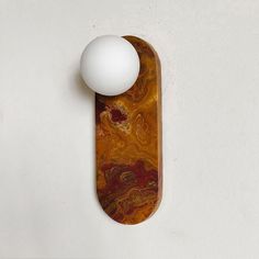 an egg sitting on top of a wooden board next to a wall mounted light fixture