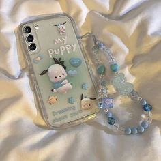 a cell phone case with an image of a puppy on it and beaded necklace
