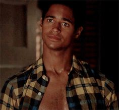 a shirtless man with no shirt standing in front of a door and looking at the camera