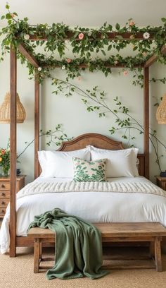 a bed with white linens and greenery on the headboard