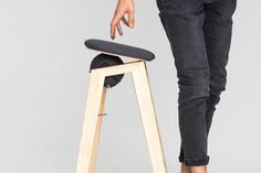 a person standing next to a stool with their foot on the seat and one leg up