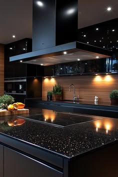 a modern kitchen with black counter tops and lights on the wall above it's sink