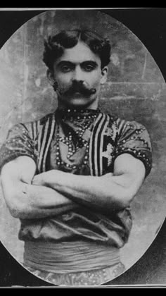 an old black and white photo of a man with his arms crossed in front of him
