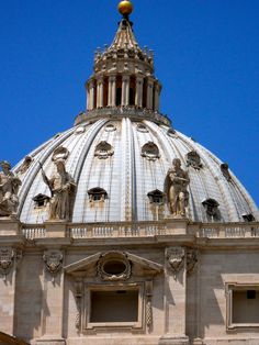 the dome of an old building with statues on it's sides and a gold ball at the top
