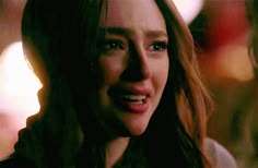 a close up of a person with long hair and blue eyes looking at the camera