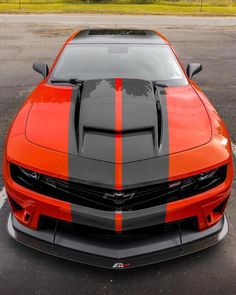 an orange and black car parked in a parking lot