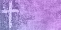 a cross on the side of a wall with purple and blue paint in it's center