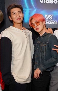 two young men standing next to each other in front of a movie poster at an event