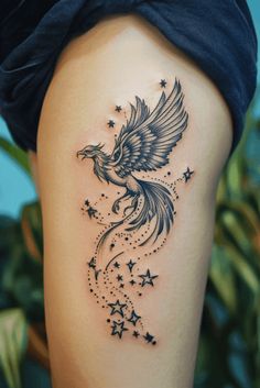 a woman's thigh with stars and a bird tattoo on the side of her leg