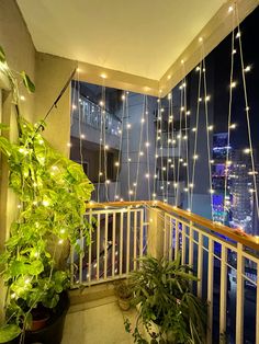 a balcony with potted plants and lights hanging from it's balconies
