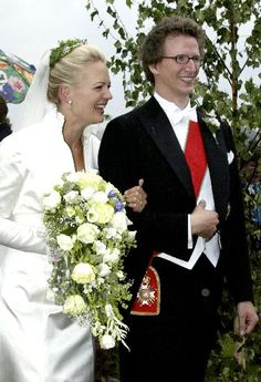 the bride and groom are walking down the street