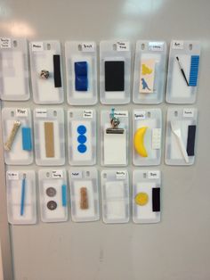 a white refrigerator freezer covered in lots of magnets and clipboards on it