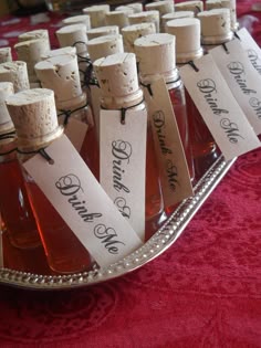 several bottles of honey sit on a silver platter with wine tags attached to them