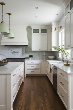 a kitchen with white cabinets and wood floors