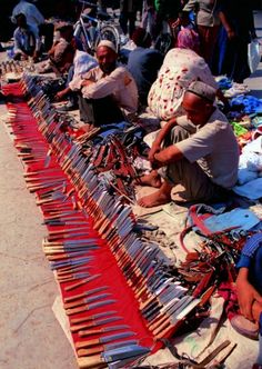 people are sitting on the ground selling items