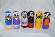 a group of mickey mouses sitting next to each other on a white sheeted surface