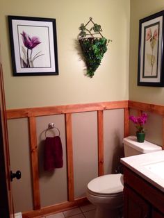 a bathroom with a toilet, sink and framed pictures on the wall above it is shown