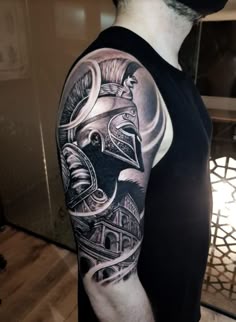 a man with a black and grey tattoo on his arm