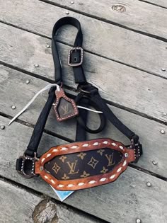 a louis vuitton belt and purse on a wooden deck, with the strap still attached to it