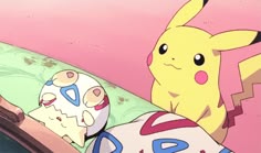 the pikachu is laying in bed next to an egg