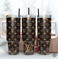 three louis vuitton travel mugs sitting next to each other