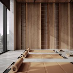 an empty room with tatami mats on the floor and large windows in the background