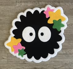 a black sheep with stars around it's eyes on a wooden floor in the shape of a circle