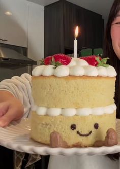 a woman holding a cake with strawberries on it