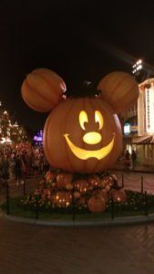 a mickey mouse pumpkin is lit up at night