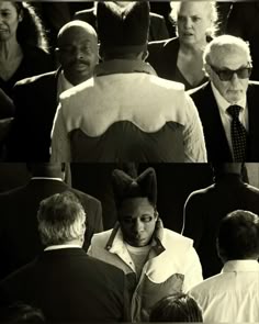 black and white photograph of man in suit surrounded by other people