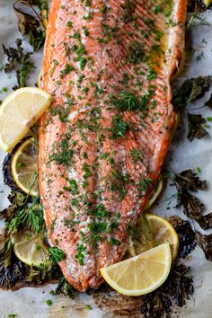 salmon with herbs and lemons on a sheet of paper