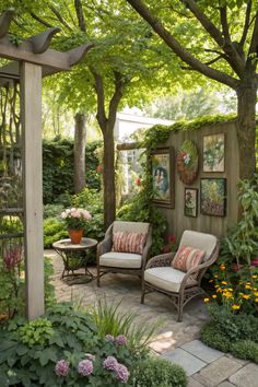 an outdoor sitting area with two chairs and a table in the center, surrounded by greenery