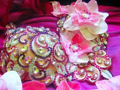 two purses sitting on top of a bed covered in pink and white flowers next to each other