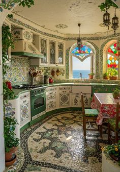 an ornate kitchen with stained glass windows and tile flooring, along with potted plants