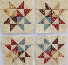 four quilt blocks are arranged in the shape of starbursts, with different colors and sizes