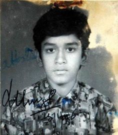 an old photo of a young man with black hair and wearing a shirt that has pictures on it