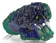 a piece of blue and green rock with crystals on it