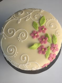 a white cake with pink and green flowers on it