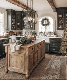 a kitchen decorated for christmas with wreaths and greenery on the island, surrounded by green cabinets