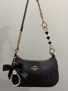 #charms #keychain #coach #coachoutlet #bow #hearts Coach Teri Shoulder Bag With Accessories, Coach Bags Charms, Coach Teri Bag Black, Coach Teri Shoulder Bag Aesthetic, Coach Teri Shoulder Bag Heart, Teri Coach Bag Aesthetic, Coach Teri Shoulder Bag Outfit, Coach Black Bow Bag, Black Coach Handbag With Bow