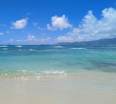 an ocean view with waves crashing on the beach