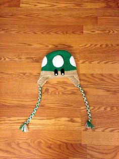 a green and white knitted hat on top of a wooden floor