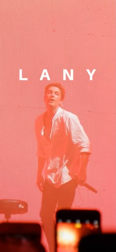 a man standing in front of a red screen with the word lanny on it