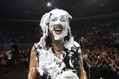 a man with white paint on his face in front of an audience at a concert