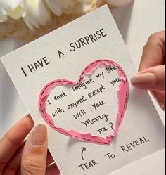 someone is holding up a card with a heart cut out of it that says i have a surprise