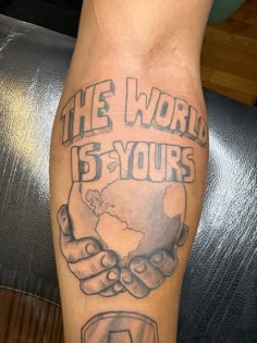 a man with a tattoo on his leg that says the world is yours and two hands holding