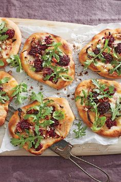many small pizzas with toppings are on a cutting board and ready to be eaten