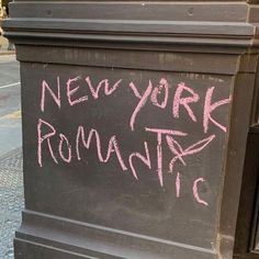 a chalkboard with the words new york romantic written in pink ink on it's side